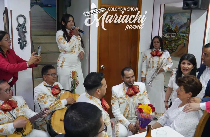 Grupo de mariachis posando de rodillas en una fiesta de quince años en Bogotá