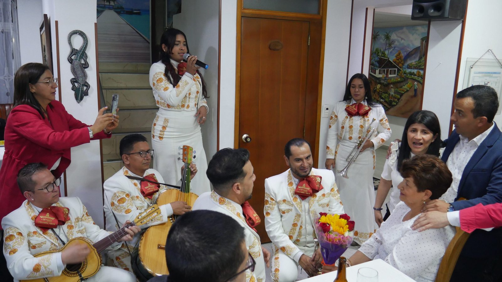 Músico de mariachi cantando de rodillas a doña Martha en su sala, Bogotá