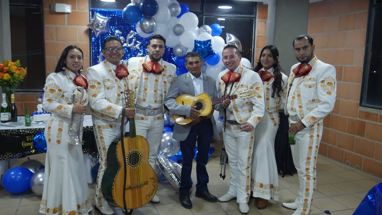 Mariachi con don Julio en su celebración de cumpleaños con globos azules, Bogotá