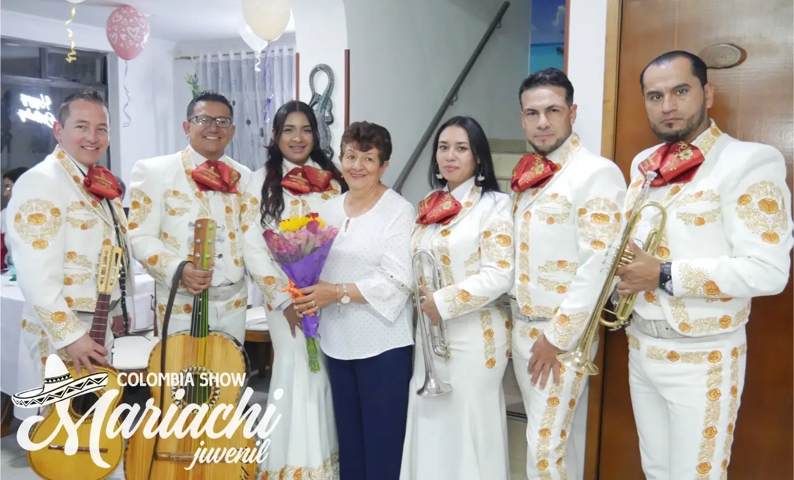 Grupo de mariachis entregando flores a una señora en el salón de su casa en Suba
