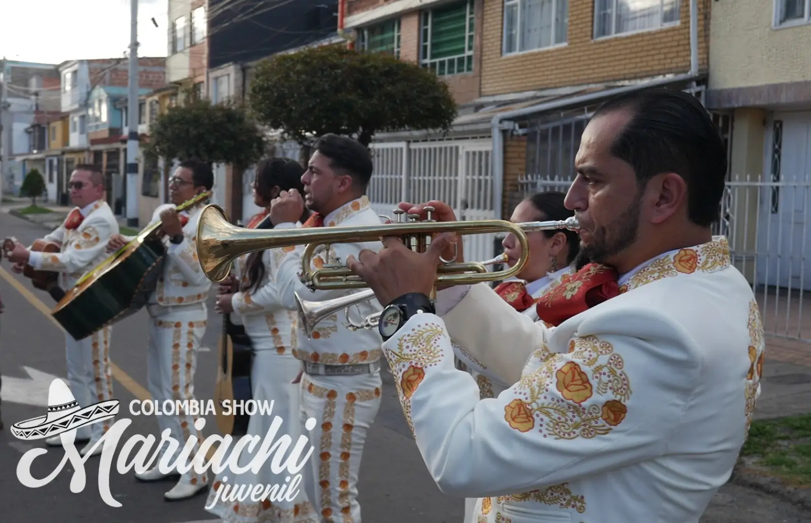 Grupo de mariachis posando de rodillas en una fiesta de quince años en Bogotá
